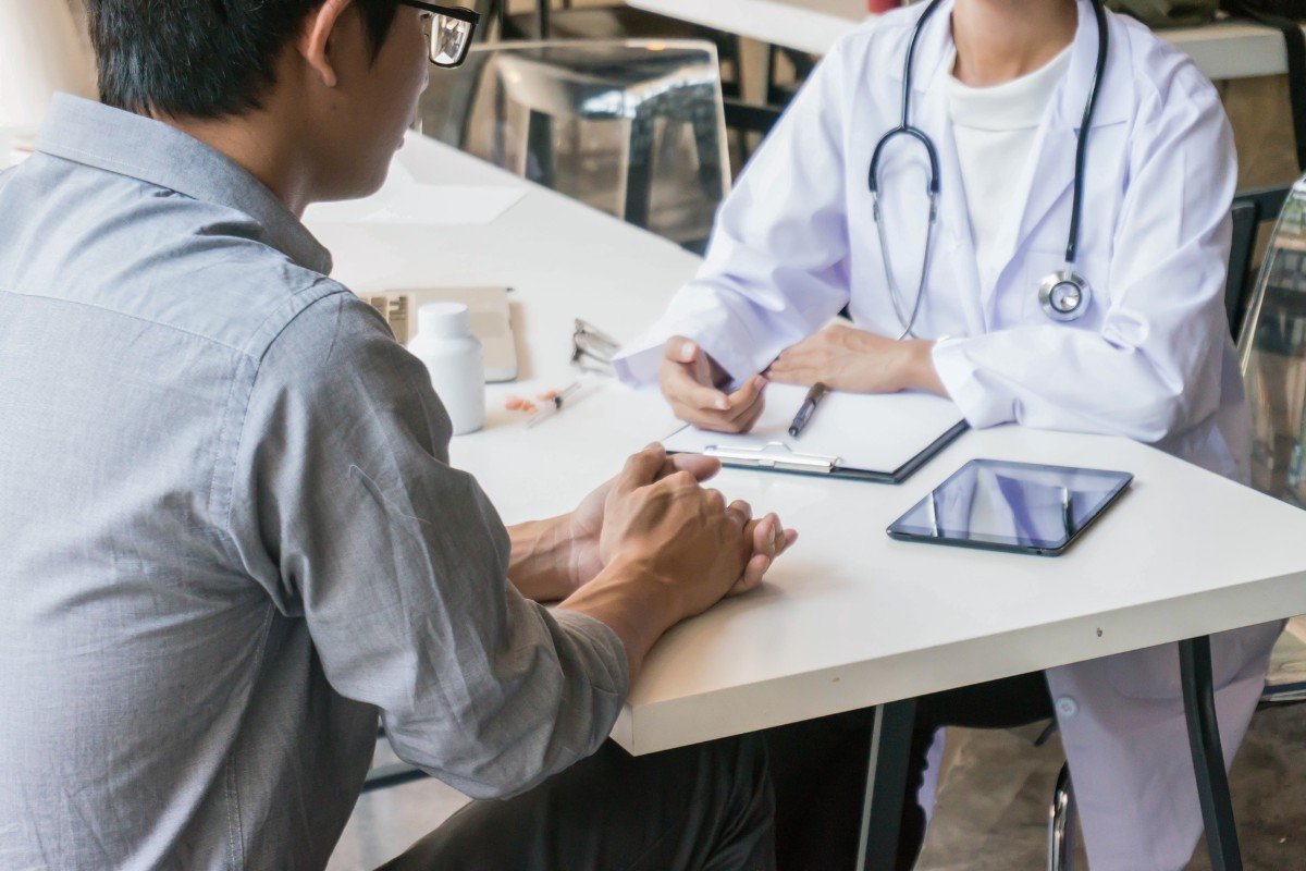 A middle-aged man sits with his doctor.